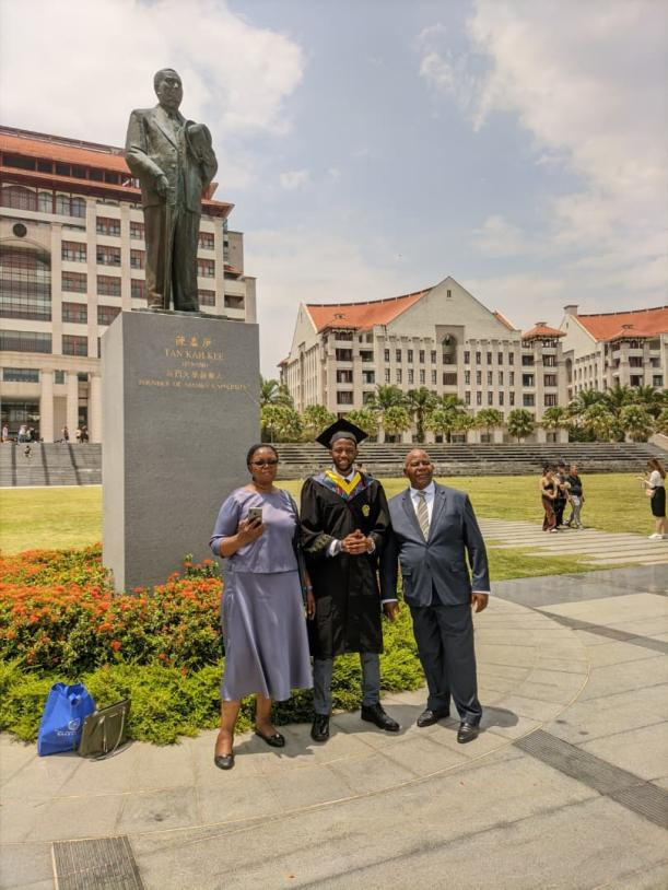 Kalumba and his family in front of Tan Kah Kee statue